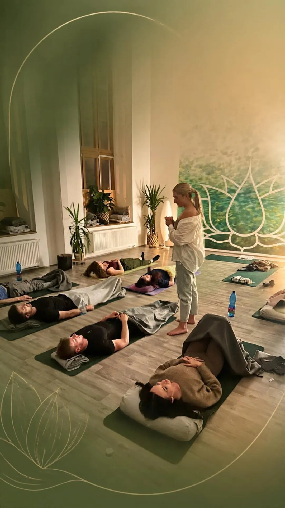 Katerina Kaslova leading a group breathwork session, people lying on mats in front of the lotus mural